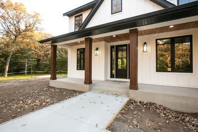 Custom Minnesota Home built by Cornerstone Custom Builds with cream siding and dark wood pillars.