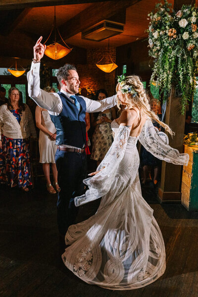 A joyful and stylish reception moment as the couple shares their first dance and celebrates at River Café, a stunning downtown Calgary wedding venue.