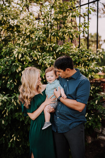Mom and dad kiss baby son for their family session at the Highlands Ranch Mansion.