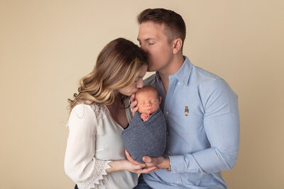 dad kissing mom kissing baby by Newborn Photography Bucks County PA