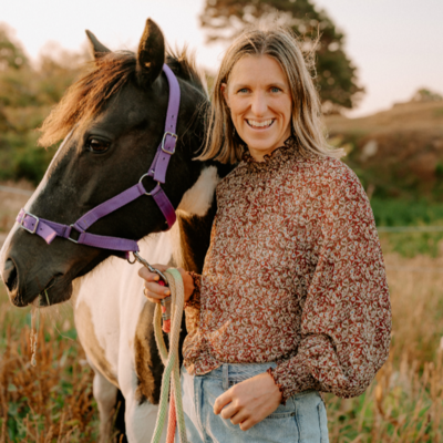 Monique Dickson stands next to a brown and white horse.