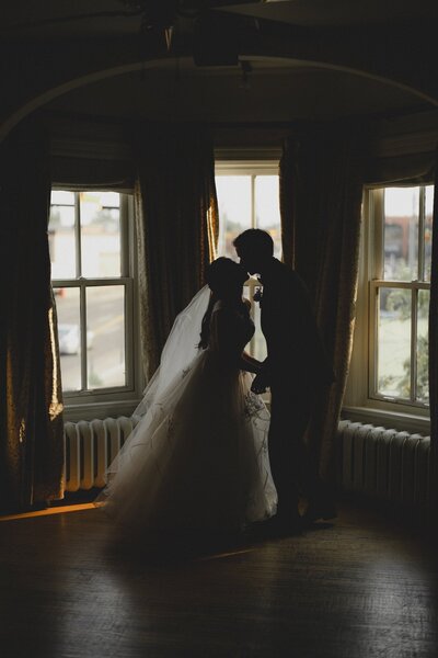 Wedding couple silhouetted while kissing at The Rouge Restaurant in Calgary