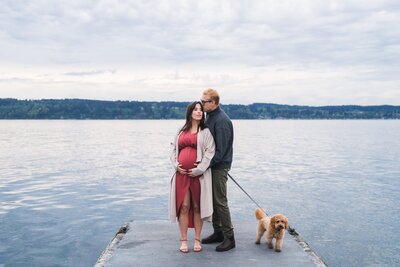 Expecting Couple standing with dog on Mukilteo Lighthouse Beach Park Dock