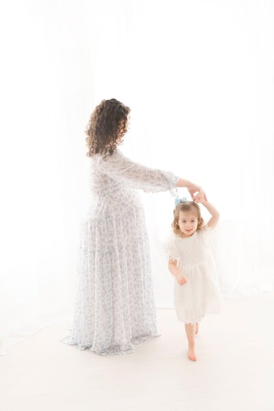 pregnant woman and child dancing in studio for maternity photographer boston ma​
