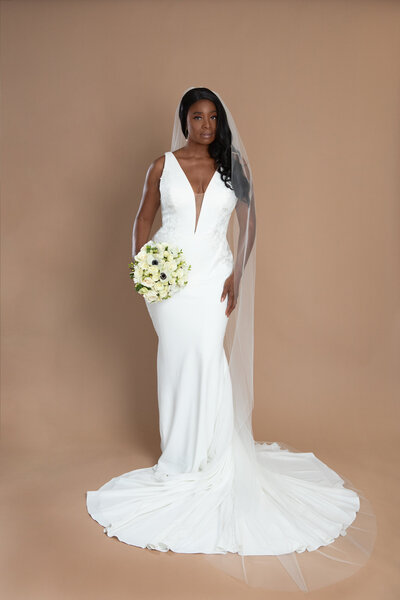 bride wearing a cathedral length veil and holding a white and blush bouquet