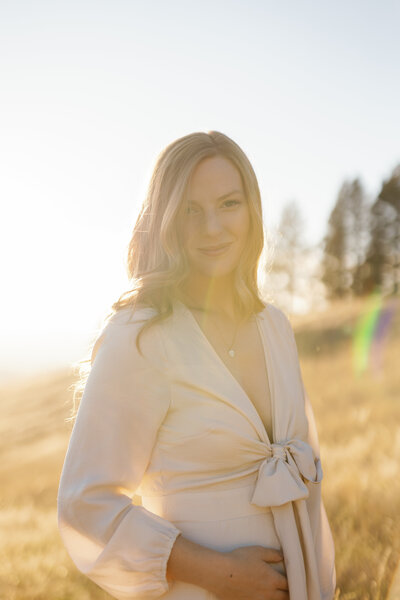 Amanda smiling in golden light, offering warmth and peace as a doula and motherhood companion.