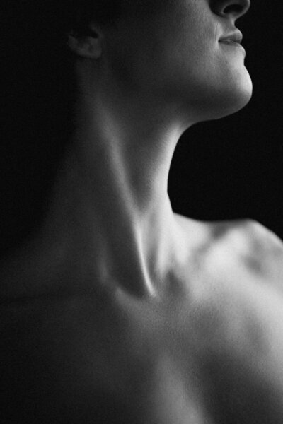 Close-up artistic portrait captured by Phoenix boudoir photographer Joy Steele, highlighting a woman’s neckline in black and white.