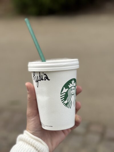 A photo of an Austin Texas Photographer holding a Starbucks cup with the name "Lydia" written on it.
