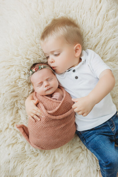 Mom and newborn baby laying in a bed cuddling in Harrisburg, PA