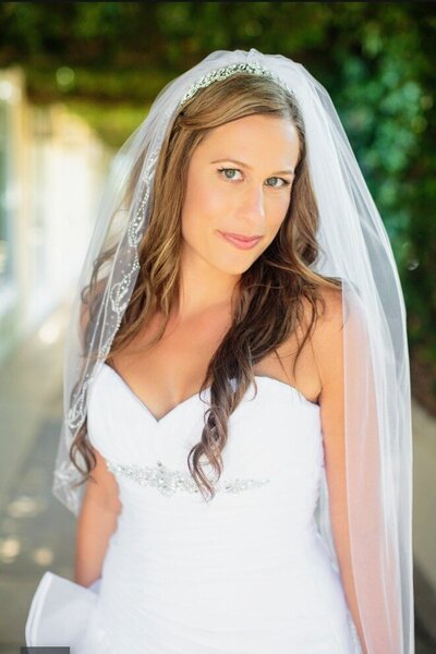 Sarah smiles happily wearing her wedding dress. She looks natural and like her most beautiful self.