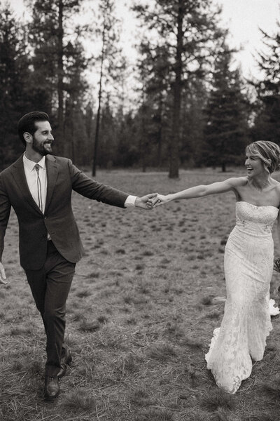 black and white image of couple on wedding day holding hands