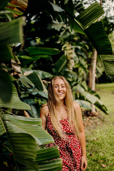 woman smiling by palm tree leaves