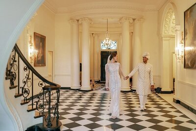 Bride walking with the tips of her veil in her hand through the Swan House Atlanta on her wedding day Michelle Scott Photography and day of wedding coordinations Tinted Events Design and Planning