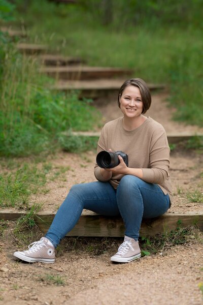 woman leaning forward  with thumbs in pocket smiling at the camera at a studio in Pueblo Colorado