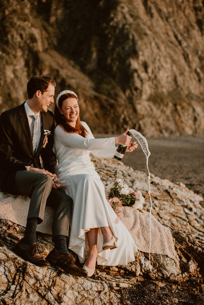 Couple laughing together on Sonoma Coast State Park beach during adventure elopement