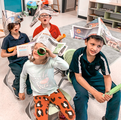 children with newspaper hats playing and learning