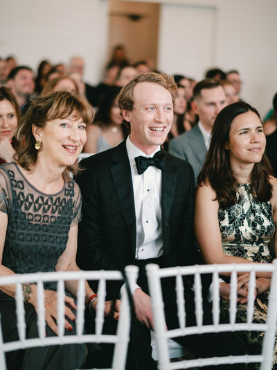 Guests at Farmhouse in Montgomery, Texas wedding laughing during ceremony