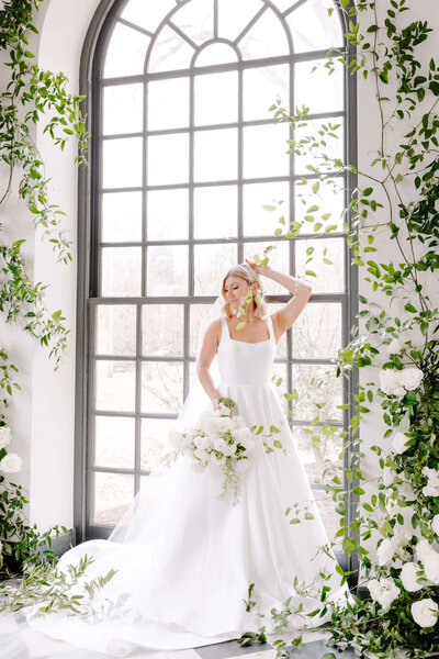 Bridal portrait at Conestoga House against large oval window and greenery