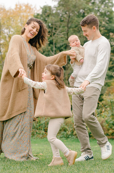 Family runs around in circles playing during their photoshoot.