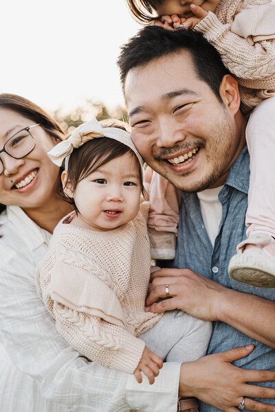 dad holding newborn with toddler