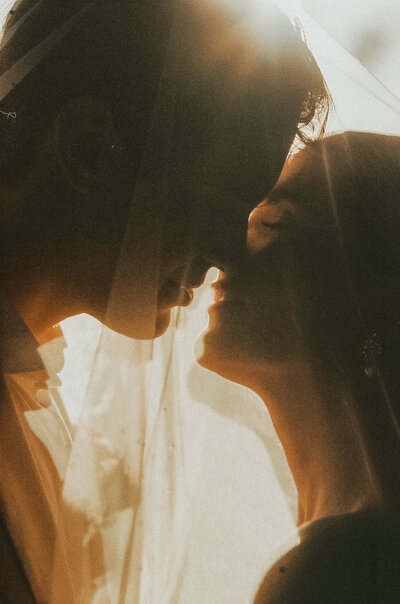bride and groom laughing in field