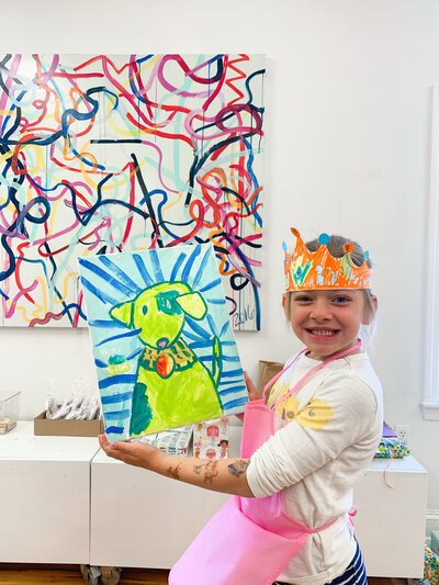 Artcie birthday party child holding up her artwork