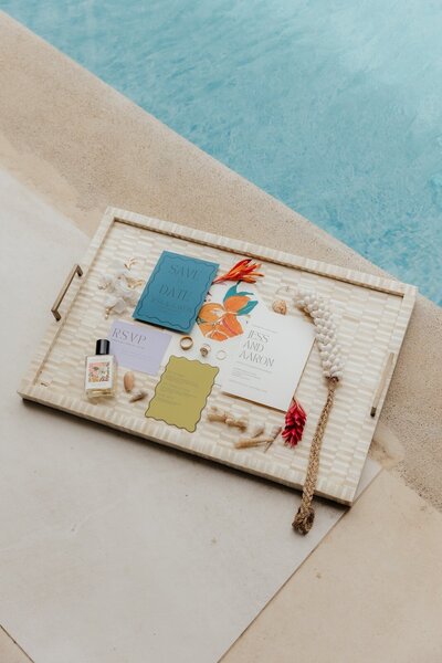 wedding invitations and jewelry next to pool in costa rica