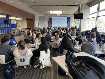 A group of college students attending Duke University listening to a presentation on mental health