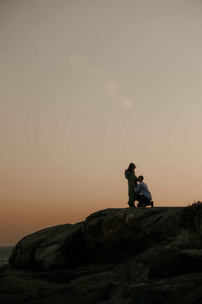 Epic outdoor maternity photography session at sunset on a cliff
