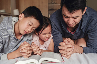 Dad praying with kids