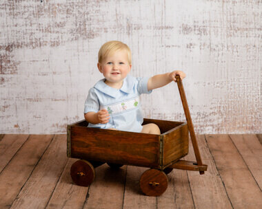 Little boy eating cake on a blue background.