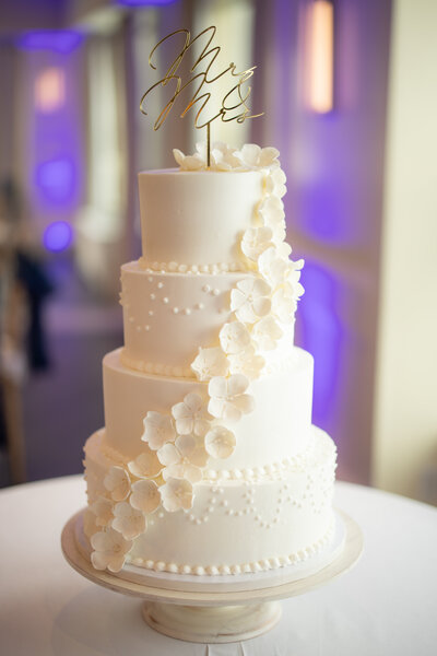 3 Tiered all white cake with flowers draping down the side