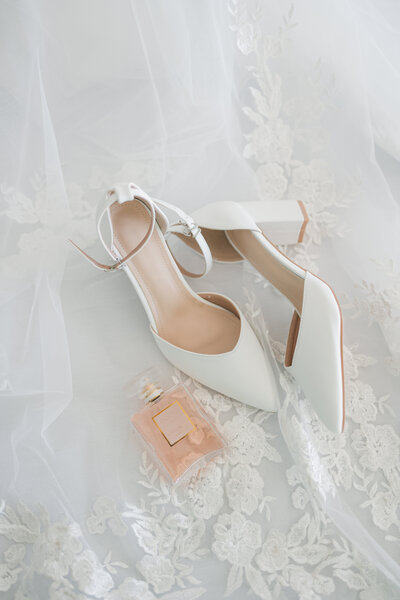Luxury and Editoral photo of a bride's shoes and perfume bottle. Photo by Maggie Alvarez Photography