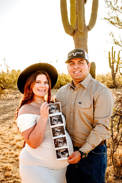 mom in Arizona holding her stomach for maternity session with photographer of Cactus & Pine Photography LLC