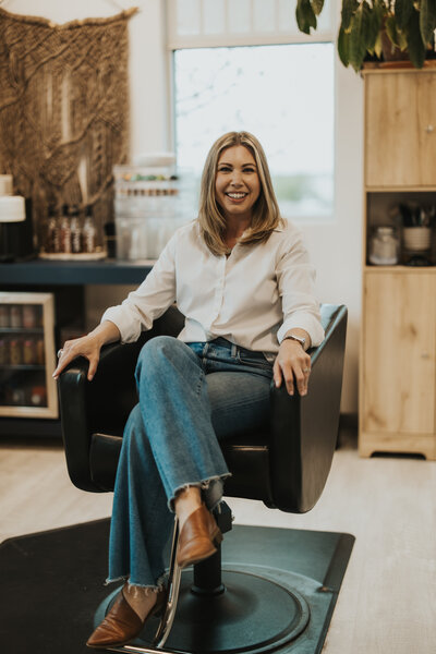 Casper, Wyoming hairstylist Emily Muhlbauer smiles in chair waiting for next appointment