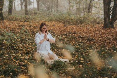 isabell Botschek sitzt im Wald in einer Yogapose