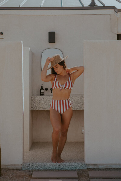 girl posing in bathroom in red striped bikini