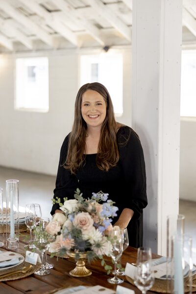 Jessica Young standing next to a table setting with wedding flowers