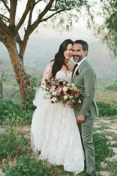 Romantic sunset wedding portraits at Malibu Dream Resort! The bride is holding a floral bouquet