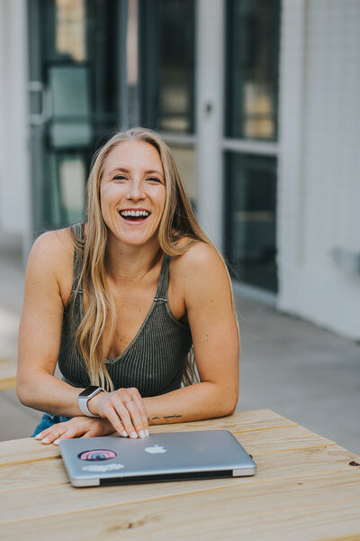 woman at a picnic table with laptop