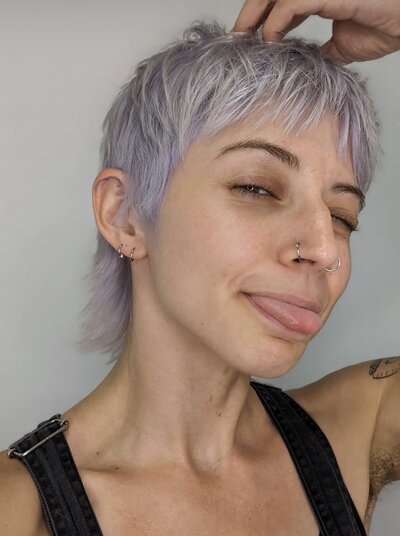Image of client with short hair that has been dyed a silver purple.