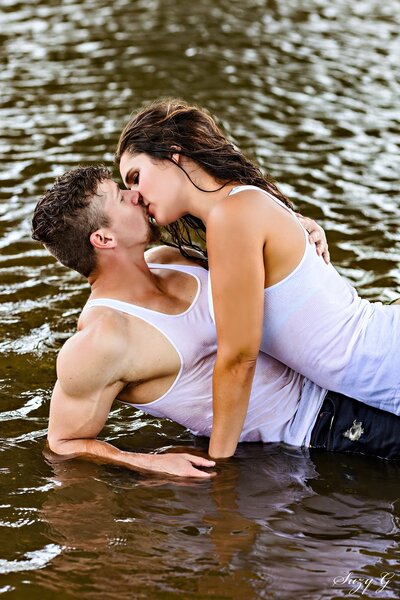 Engagement photo of a beautiful couple. Bride to be is kissing groom to be on the cheek.