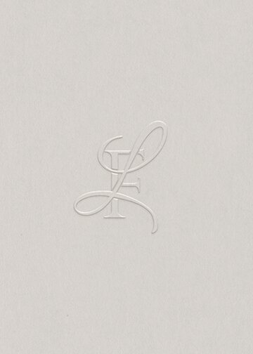 Embossed Baer Brand Studio Monogram featuring an elegant, intertwined cursive 'L' and 'F' in a minimalist design on a light textured background.