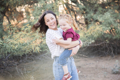 dark brown haired young woman spinning around with redheaded niece