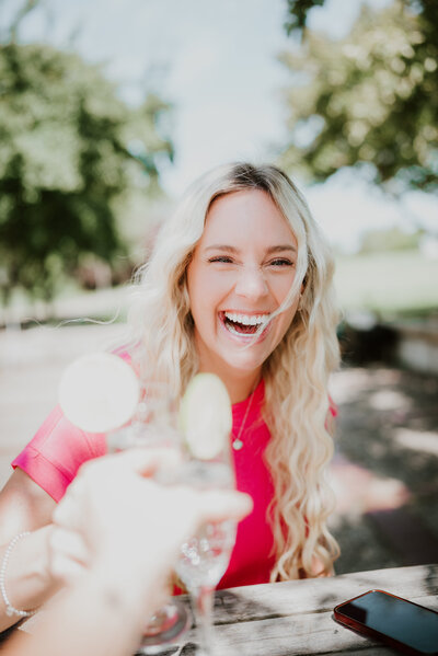 Bright outdoor portrait of a smiling woman in natural light, captured during a professional online dating photo session by Shannon Kathleen Photography