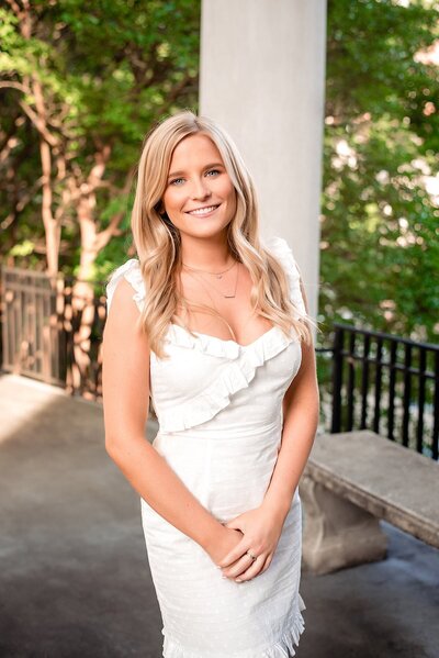 Girl wearing a cute white dress and smiling at the camera