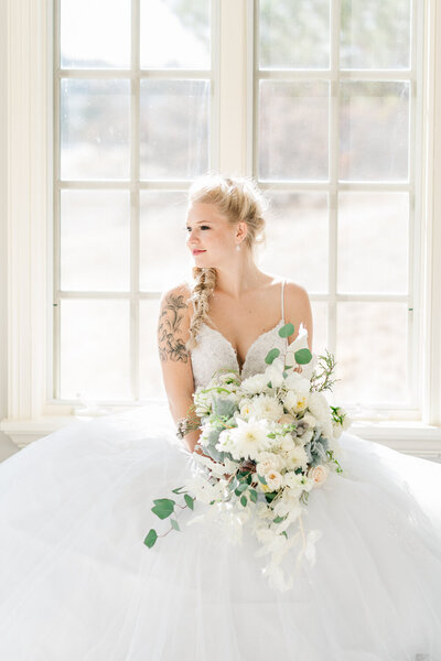 A Colorado bride looks out the window on her wedding day.