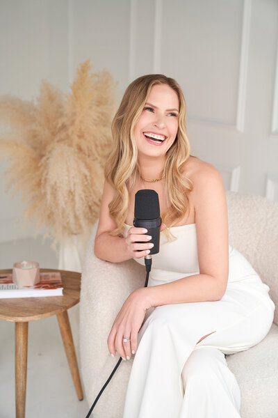 woman holding a microfone preparing for a podcast