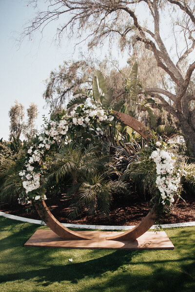 Full round dark wood wedding arbor with white rose decoration