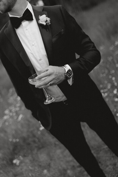 Groom sipping on martini at his luxury wedding at Camp Hale in Vail, Colorado captured by Gracie Wilson Photography. 